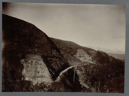 Road construction along the southern slope of Woih ni Enang. Tipped-in photo in an album with 87 photos about the construction of the Gajoweg in North Sumatra between Bireuen and Takinguen between 1903-1914.